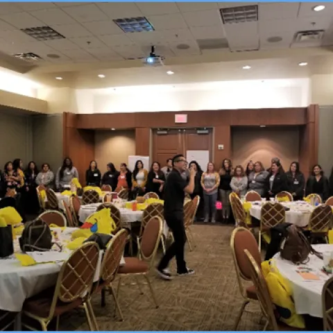 Eldon Bueno, CFHL, UCCE Kings Nutrition Educator explaining CATCH activities as participants stand and observe from around the workshop venue.