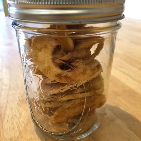 Small glass jar filled with dried apple rings