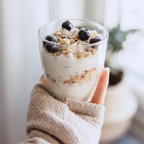 Person holding a yogurt parfait