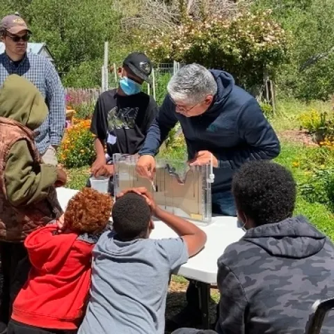 Sam Sandoval Solis, especialista de la Extensión Cooperative de la UC, en el centro, demuestra a los alumnos de quinto grado cómo el agua superficial fluye hacia el agua subterránea.