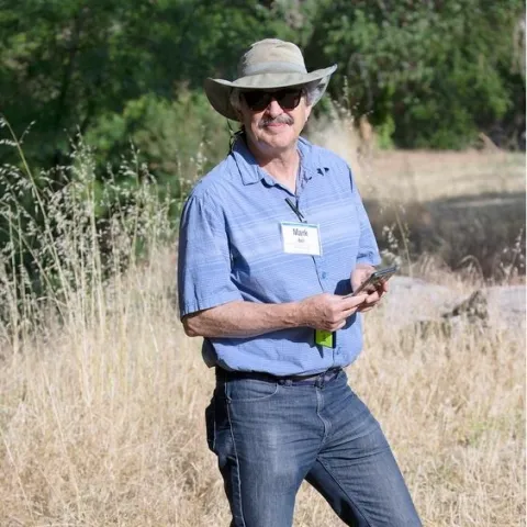 Bell stands in in dry grass.