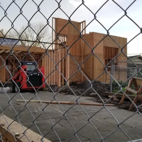 House undergoing remodeling. The construction is down to the two by fours and ply board on the new addition.
