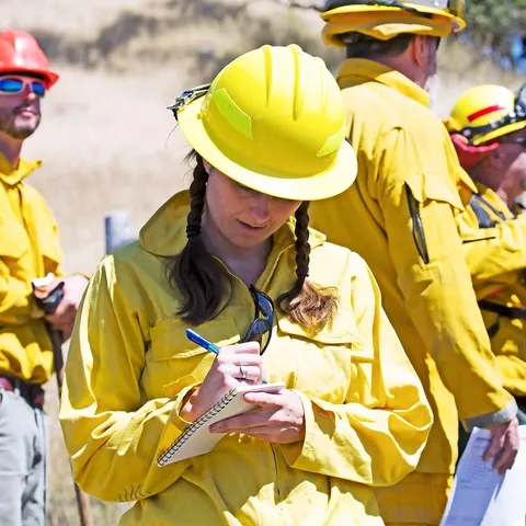 Young woman takes notes at a prescribed burn