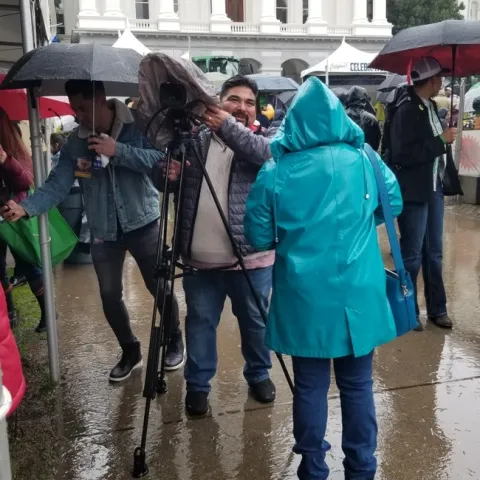 Strat Comm members Maguel Sanchez (with camera) and Pam Kan-Rice (in raincoat) do their thing!