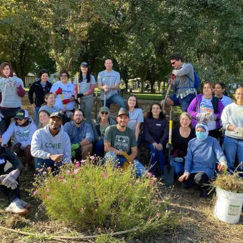 A group of volunteers pose for a photo in a garden
