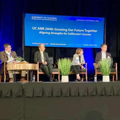 Six people sit on stage under a banner that reads: “UC ANR 2040: Growing Our Future Together, Aligning Strengths for California's Success”