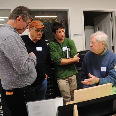 In this 2017 archived photo, Jerry Powell (seated at microscope) talks to colleagues at a Lepidopterist Society meeting at the Bohart Museum of Entomology. From left are entomologist Max Klepikov of Berkeley; UC Davis distinguished professor Don Strong of the Department of Evolution and Ecology; and Eric Lopresti, then a UC Davis graduate student. (Photo by Kathy Keatley Garvey)