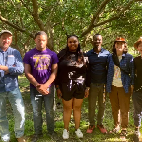 The group stands among trees