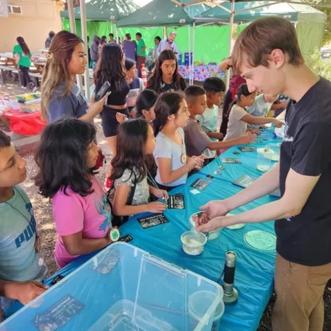 A volunteer shows spiders and other creatures to students