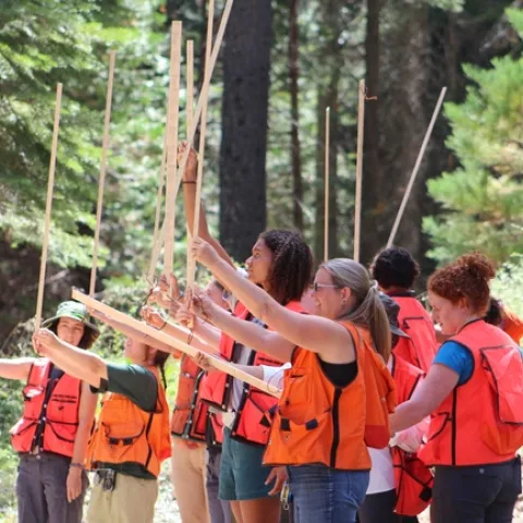 UC ANR’s Susie Kocher and Katie Reidy leads Tuesday’s ‘forestry skills’ section. Here, students learn how to use a California tree stick. Photo credit: Karina Bencomo.