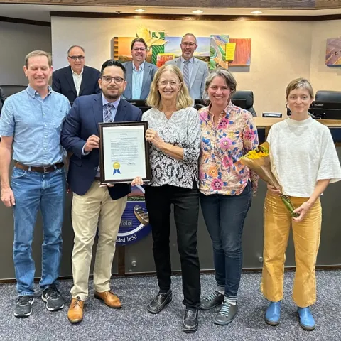 Rachael Long and Supervisor Angel Barajas hold up a plaque.