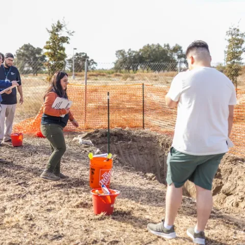 Professor Elizabeth Mosqueda (in orange shirt) instructs her students at the soil pit in the Master Gardeners' Three Sisters Garden. (Photos: Sarah Del Pozo)