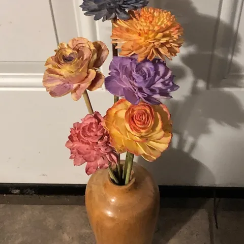 Wooden vase with 6 painted sola flowers. From tallest to shortest flower-dark blue mum, yellow and orange mum, light purple and yellow rose, lavender rose, yellow with red edged rose, and pink rose