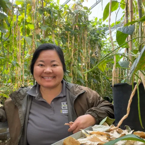 Lilian poses with a long bean varietal project.
