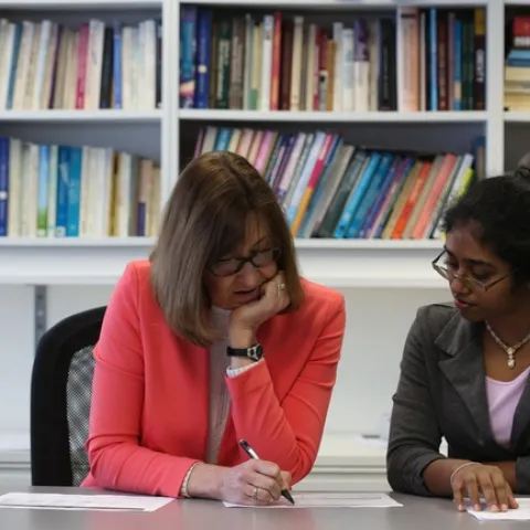 NPI director Lorrene Ritchie sits with Sri Hewawitharana in the NPI conference room