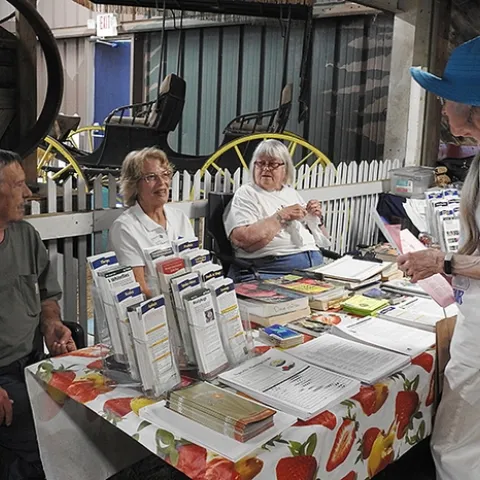 Marilyn Sexton of Fairfield, who plants tomatoes every year, asks a question at the UC Master Gardeners table at the Dixon May Fair. Master Gardeners (from left) are Tom Hutson, Julie Smith, and Betty Buxton. (Photo by Kathy Keatley Garvey)