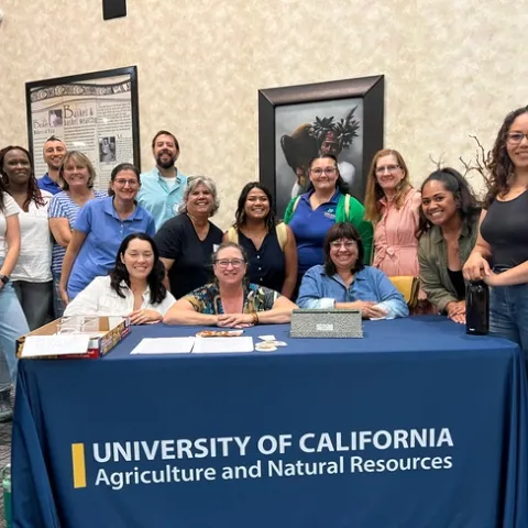15 people from UC ANR standing aroud the registration table at the Pala Tribal Partnerships workshop