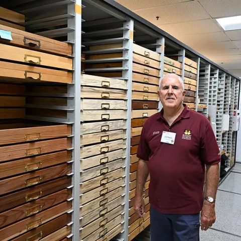 Jeff Smith, curator of the Lepidoptera collection at the Bohart Museum, stands by the drawers he crafted. (Photo by Kathy Keatley Garvey)