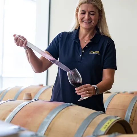Anita Oberholster, a professor of Cooperative Extension in the Department of Viticulture and Enology, extracting wine from casks in the Teaching and Research Winery. (Jael Mackendorf / UC Davis)