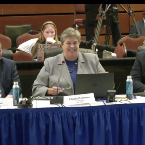 From left, Tu Tran, Glenda Humiston and Brent Hales are sitting at a long table and smiling.