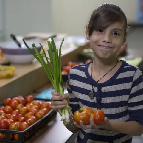 girl holding vegetables