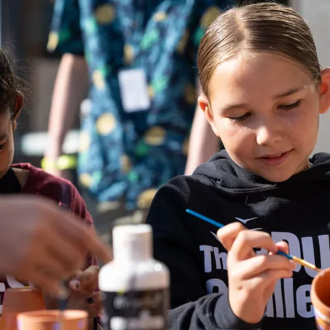 2 youth painting flowerpots