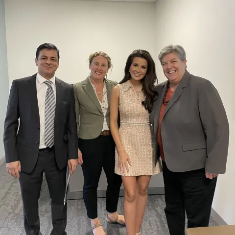 Four people stand in a row