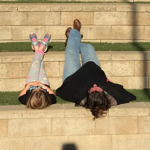 youth and adult laying side by side on their backs on a tiered platform