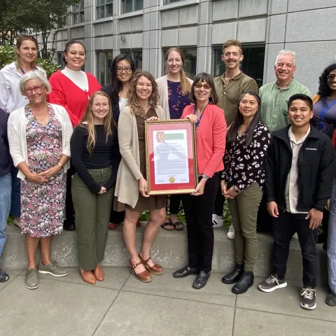 Nutrition Policy Institute team celebrates with a resolution recognizing their achievements