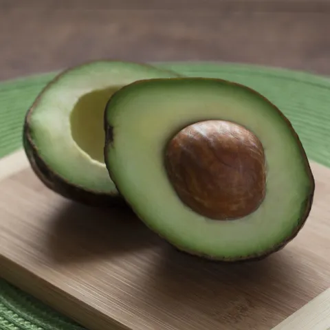cut avocado displaying brown pit and green flesh