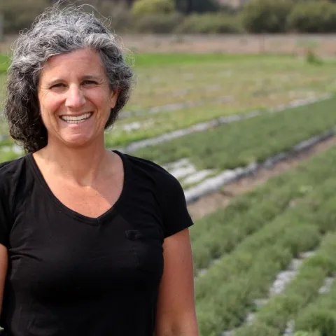 Emily Jane Freed smiles in a field of thyme at Jacobs Farm/del Cabo, Inc. in Santa Cruz County