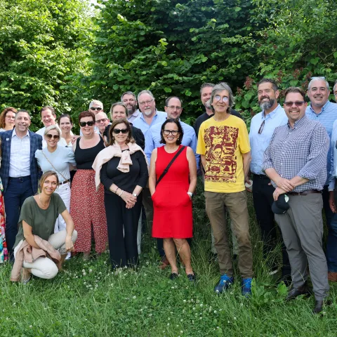A group of people pose on a green lawn