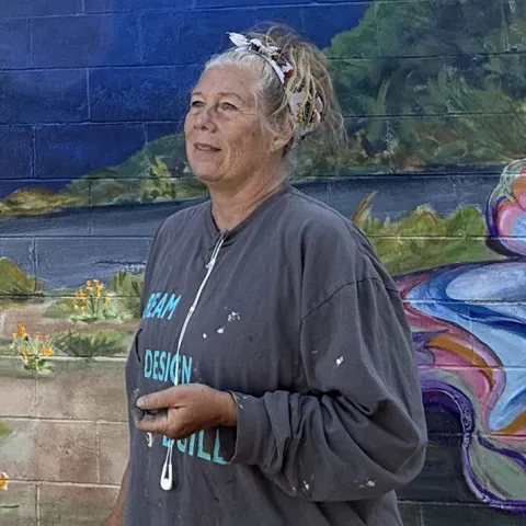 Muralist Joi McNeil in front of her large-scale mural in Vacaville.