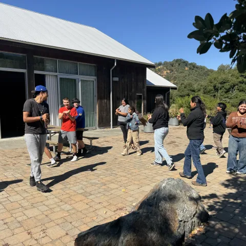 Tribal youth participate in a traditional hand game