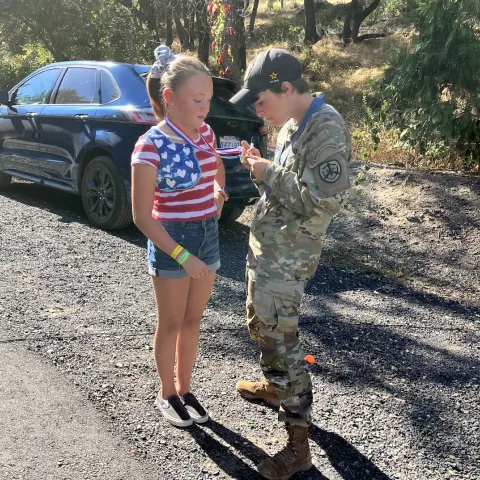 Sagen signs an autograph for a blonde girl wearing red, white and blue