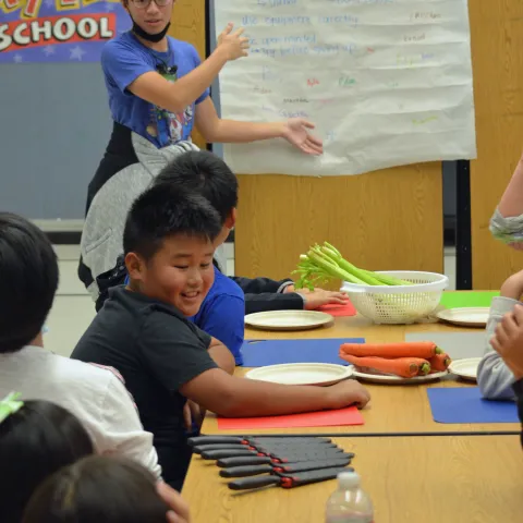 A teen teacher volunteer leads a Cooking Academy lesson at Mary Tsukamoto Elementary School in Sacramento, California.