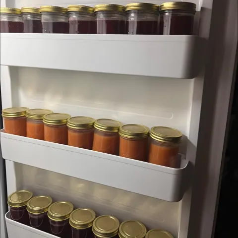 Inside of a freezer door, three rows of freezer jam in straight-sided glass jars with at least 1/2 inch of headspace