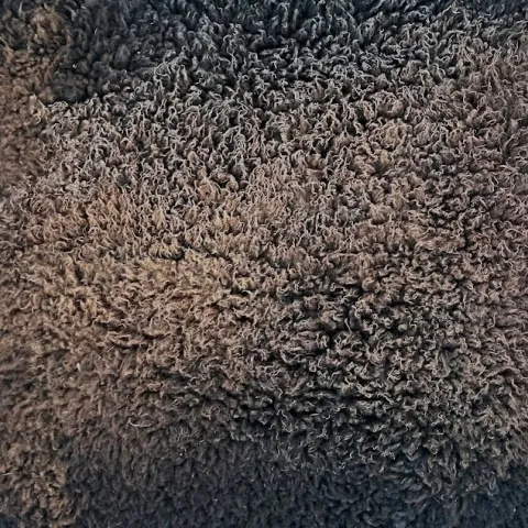 A chocolate brown fleece tanned sheep hide.