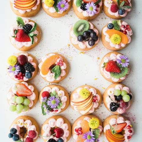 Cookies topped with fruits and flowers.