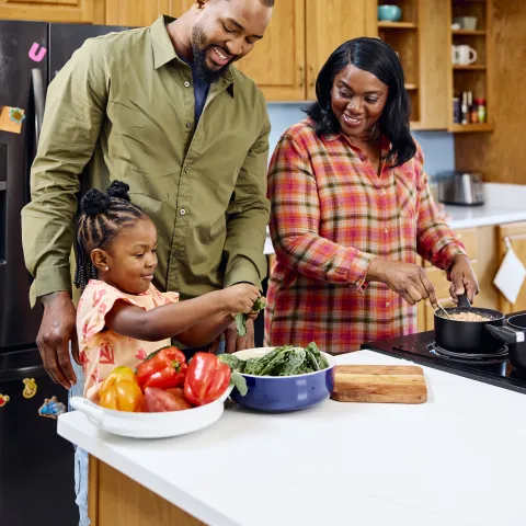 Image of a grandma, dad, and young child preparing a meal together in a home setting. Credit: USDA. 