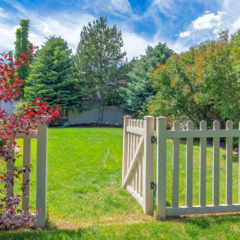 Garden gate leading on to a green lawn