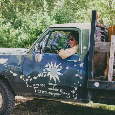 Laurie "Lio" Wayne leans out the driver's side window of a truck at her Locavore Farms