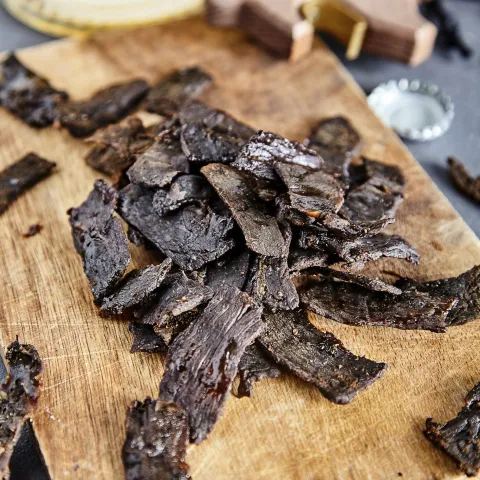 Cutting board with beef jerky on it