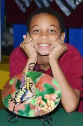 Ian Mayhew, 10, of Vallejo, shows his mother's art. His mother, Iris Mayhew, painted this rendering of a Western tiger swallowtail. (Photo by Kathy Keatley Garvey)
