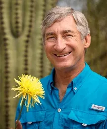 Entomologist Stephen Buchmann holds a chrysathemum. (Photo by Kay Richter)