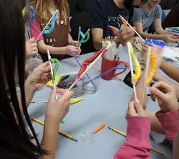 Close-up of the family arts and crafts activity--making wiggling caterpillars. These are the hands of Brownie Girl Scouts, from Troop 1585, Oak Grove.