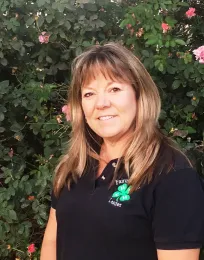 Image of Tracy Newton with rose bush in background