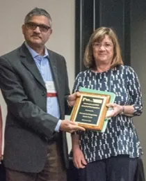 On behalf of the European Grapevine Moth Team, team leader Lucia Varela, UC IPM advisor for the North Coast, receives the team award from presenter Megha Parajulee of Texas A&M AgriLife Research. (Photo by Lena McBean, Remsberg Inc.)