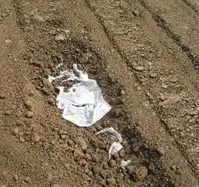 Pouches placed in soil to be buried