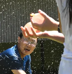 In this 2017 photo, Kai Wang, a graduate student from China in Bruce Hammock's international lab, ducks as he eyes the water balloons. (Photo by Kathy Keatley Garvey)